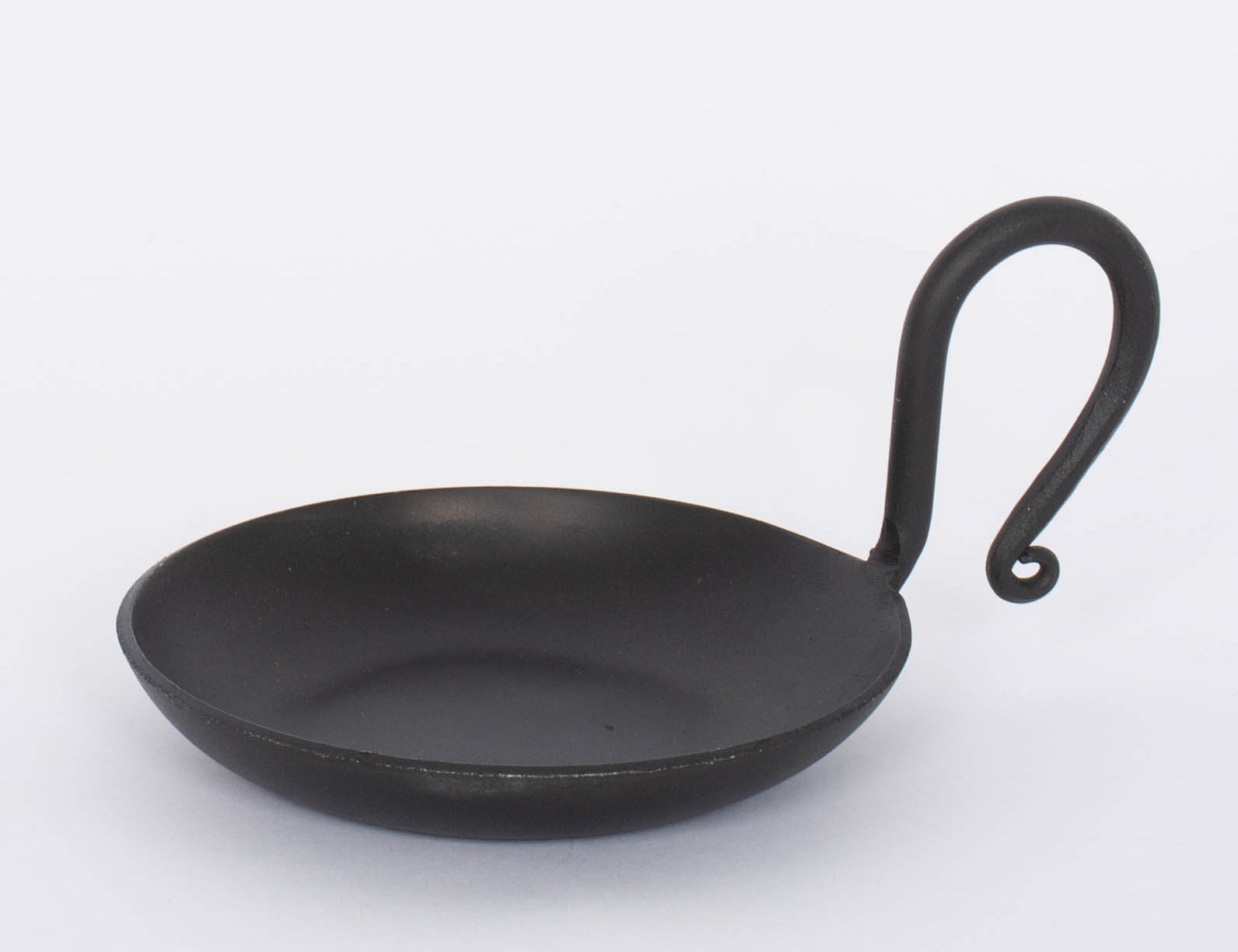 Handmade Forged Cast Iron Serving Dish with black matte finish and thin curving handle.  White background.