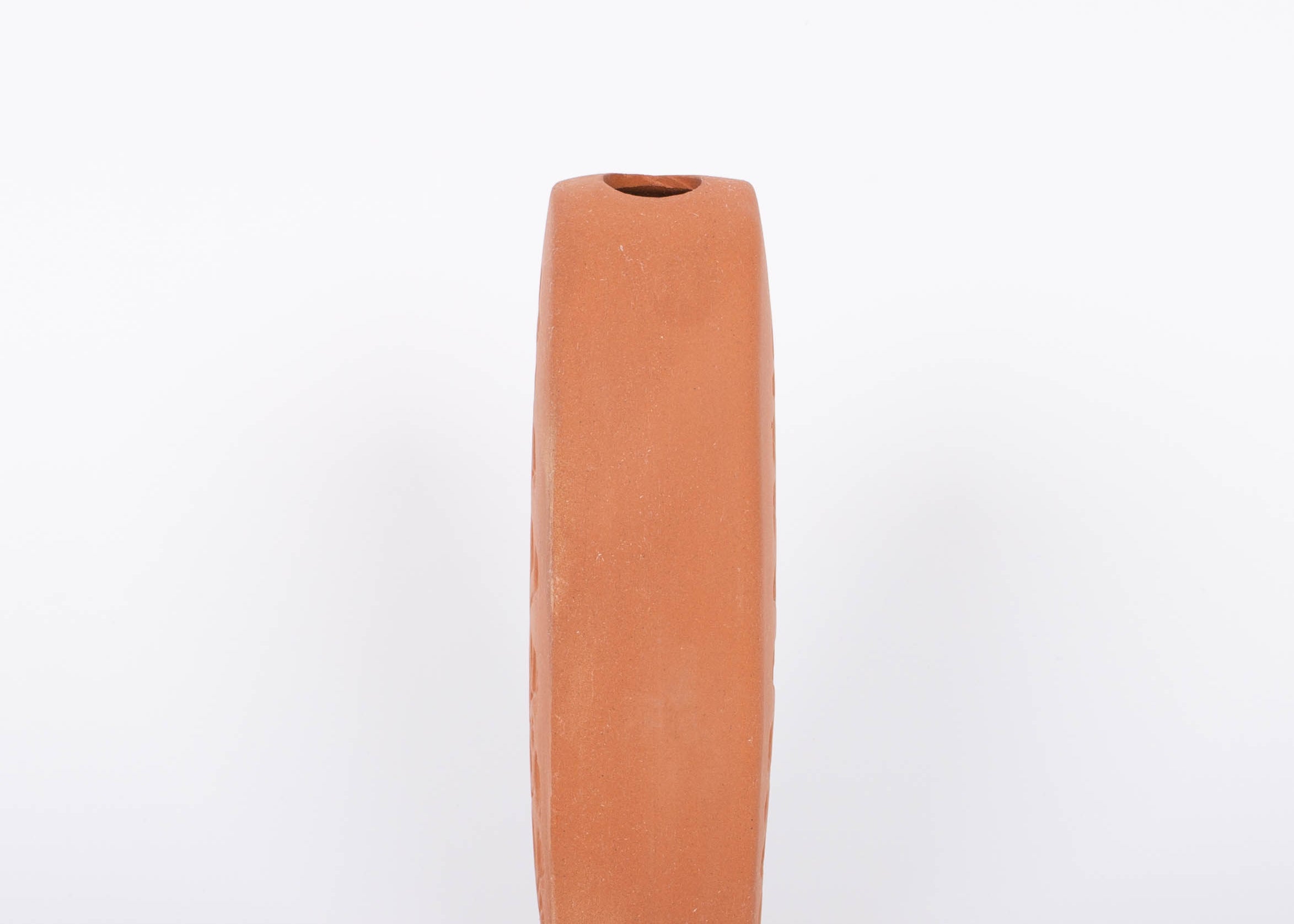 Tall oval Poppy Budvase in terracotta geometric silhouette with imprint of live plant. Side view. White background.