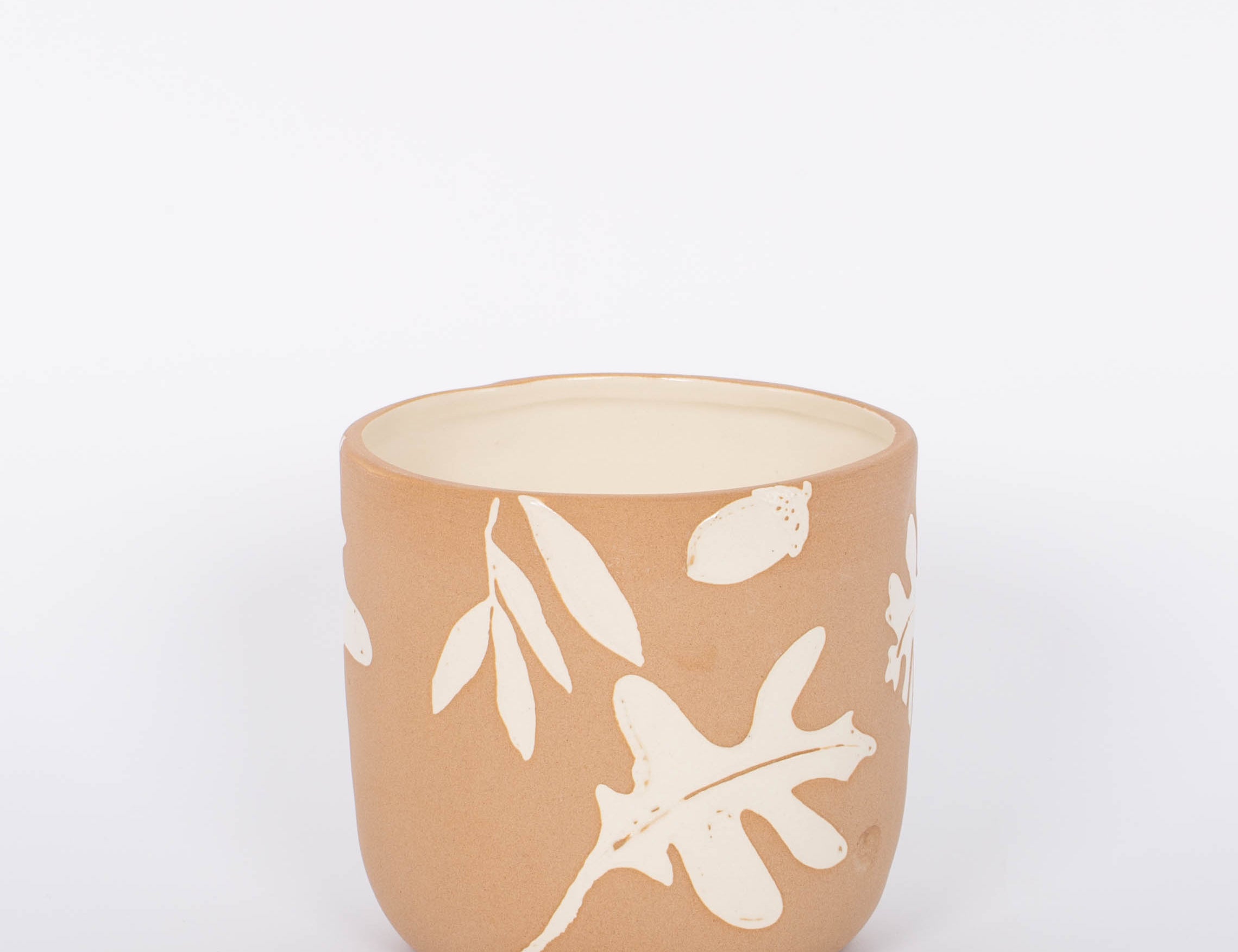 Rustling Pot with oak leaves and acorns pattern in white glazed ceramic and natural bisque. White background.