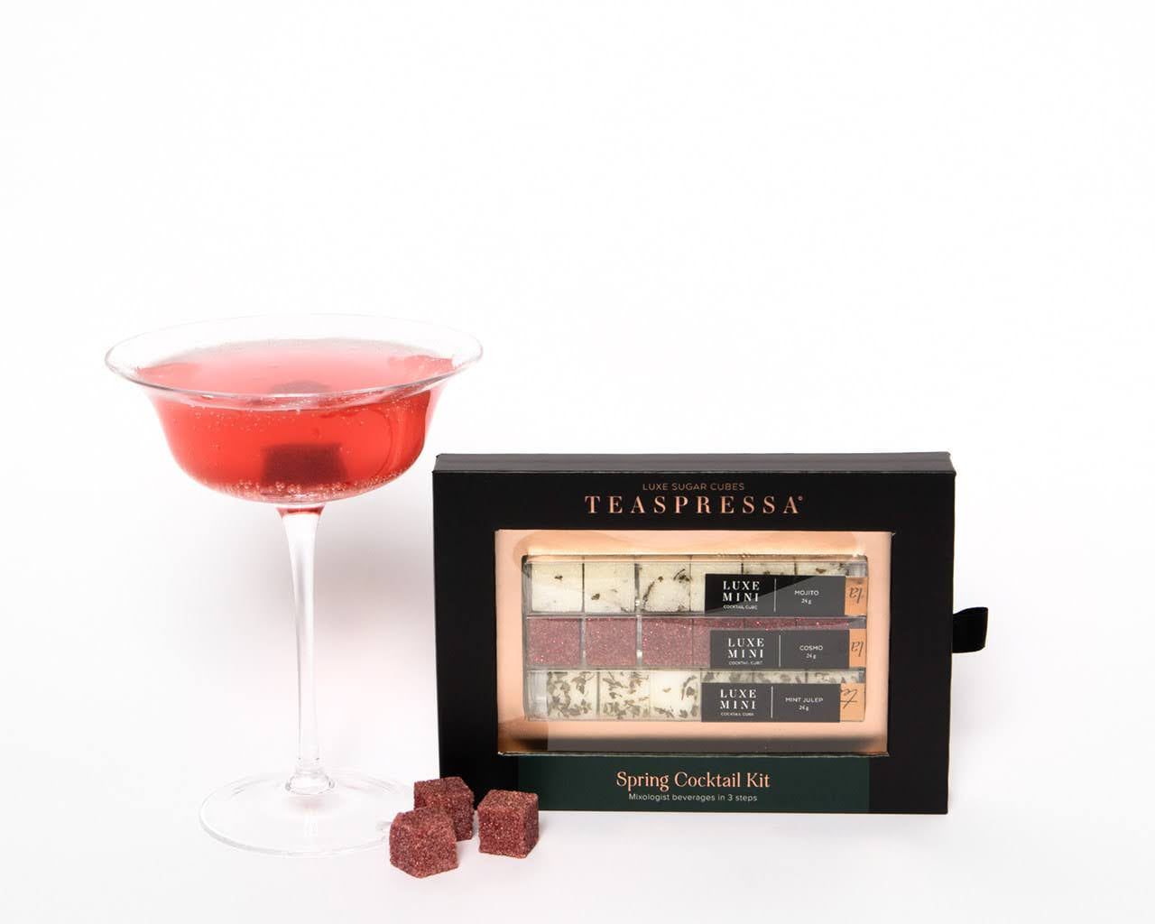 Luxe Mini Instant Cocktail Cubes by Teaspressa showing white and red cubes. Some cubes sitting outsite next to red cocktail drink. 