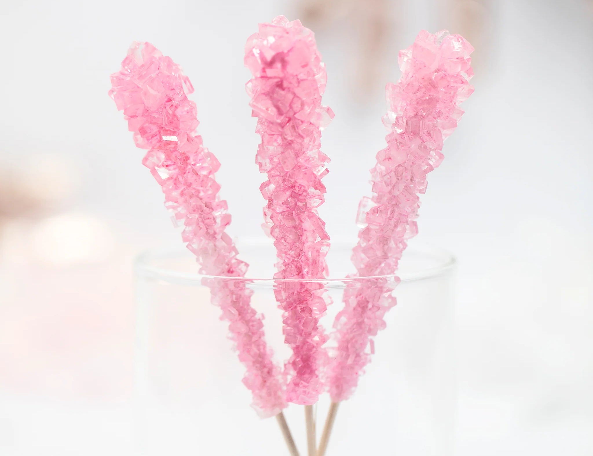 Three Nostalgic bubblegum flavored Think Pink Rock Candy by Lolli & Pops in clear class.