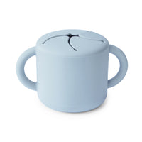Mushie Snack Cup in Powder Blue, a silicone cup with two handles and a slotted spill-proof lid