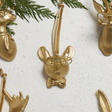 E + E Ornaments, sixteenth view, the gold mouse with a bow tie beside cedar greenery