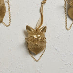 E + E Ornaments, eighteenth view, the gold fox and its chain laid flat on a white surface