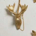 E + E Ornaments, fourth view, the gold moose with a monocle and chain on a white surface