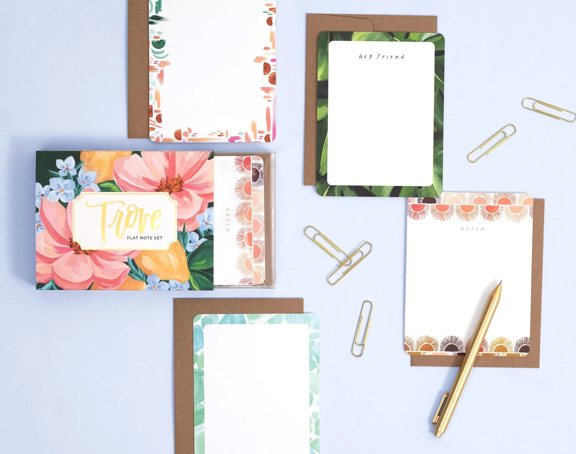 1canoe2 Trove Flat Notes with floral borders laid out with kraft envelopes and a gold pen