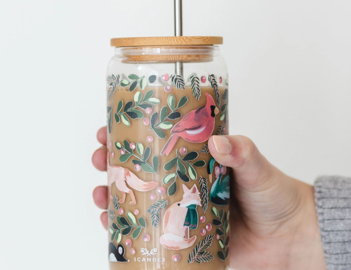 Hand holding the 1canoe2 Woodland Animals Glass Can filled with an iced coffee