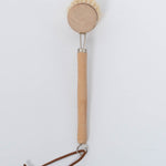 Beech Wood Flat Dish Brush with Leather Strap and silver accents for hard to reach places with angled head and nine inch handle. Brush facing down vertical view on white background.