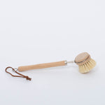 Beech Wood Flat Dish Brush with Leather Strap and silver accents for hard to reach places with angled head and nine inch handle. Brush facing down on white background. 