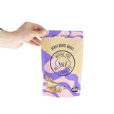 Hand holding a package of 'Winnie Lou' dog treats with a purple and yellow design.