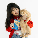 Woman holding a cat and a coffee cup with a white background