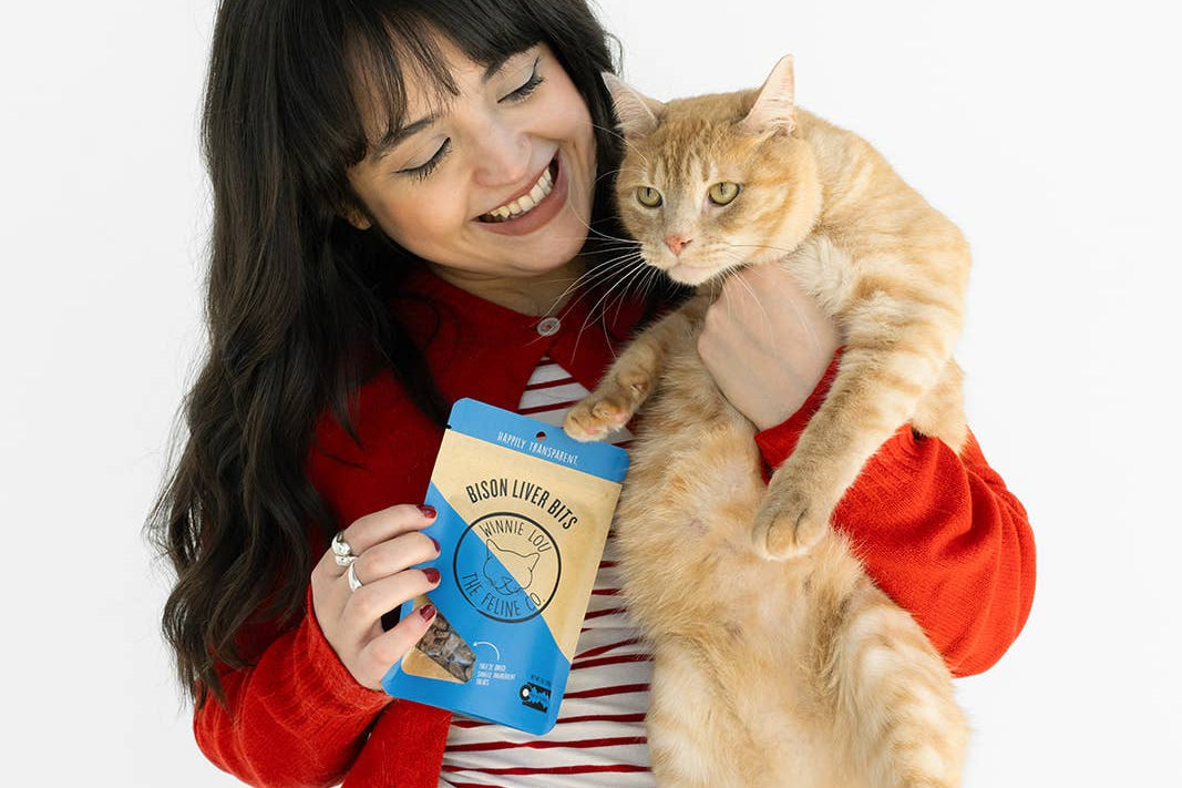 Woman holding a cat and a coffee cup with a white background