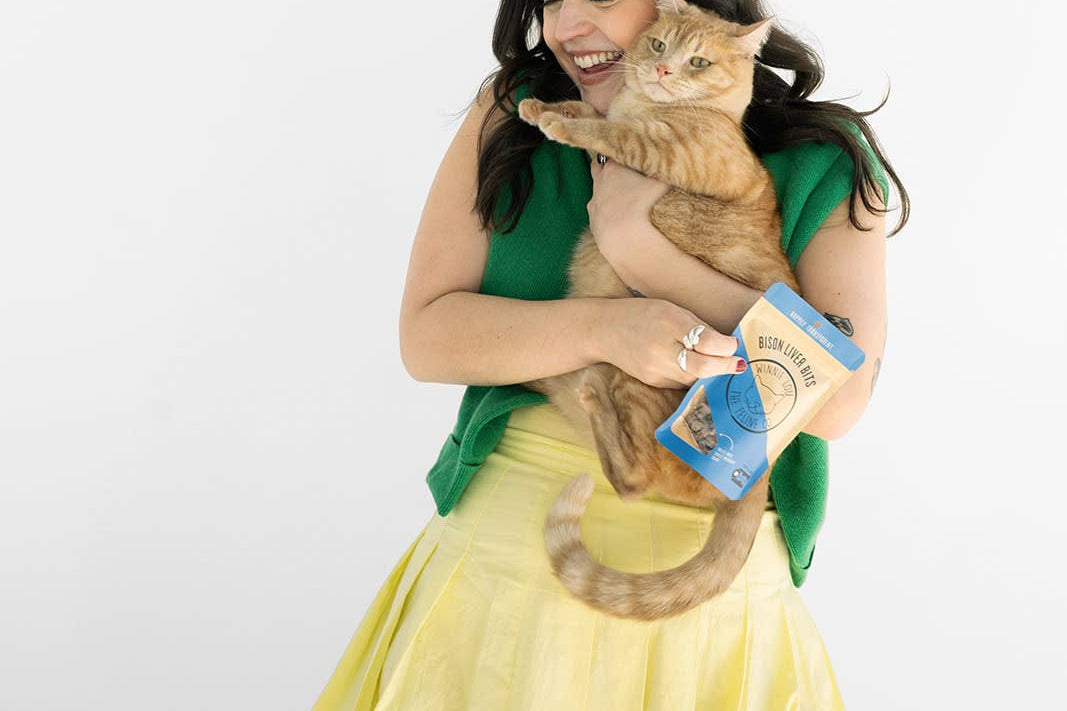 Woman holding a cat and a book on a white background