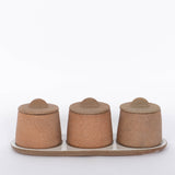 Canyon Decorative Spice Jars by Citrine Set of 3. Crafted from exposed reddish-brown earthenware with white glaze. Paired with tray. White background.