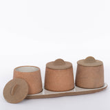 Canyon Decorative Spice Jars by Citrine Set of 3. Crafted from exposed reddish-brown earthenware with white glaze. Paired with tray and one lid off. 