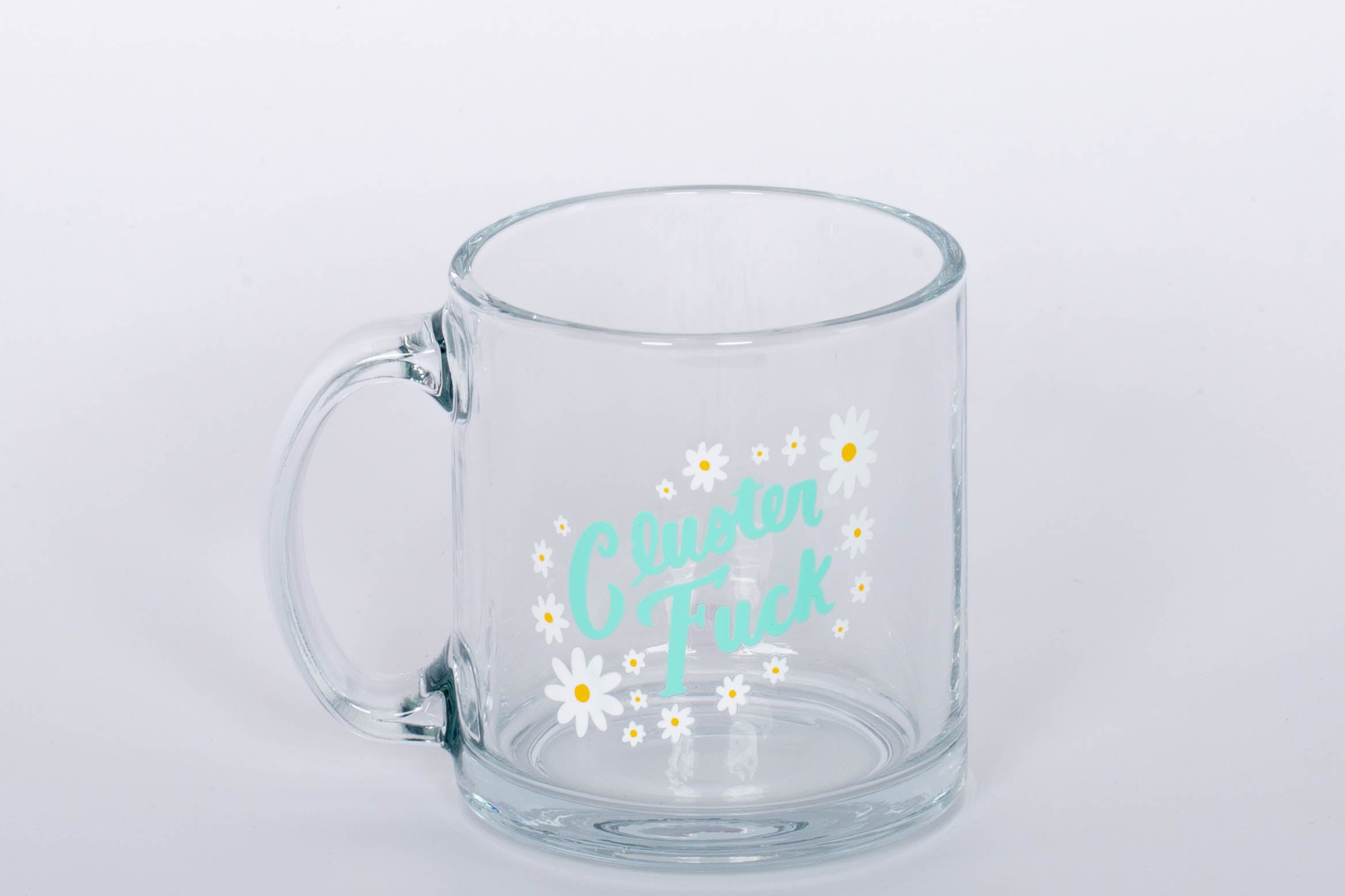 "Cluster Fuck Mug" Glass mug with blue type and white and yellow flower design.