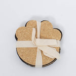 100% Recycled Dog Paw Rubber Coaster Set in tan and black by Ore Originals tied together with cream ribbon.
