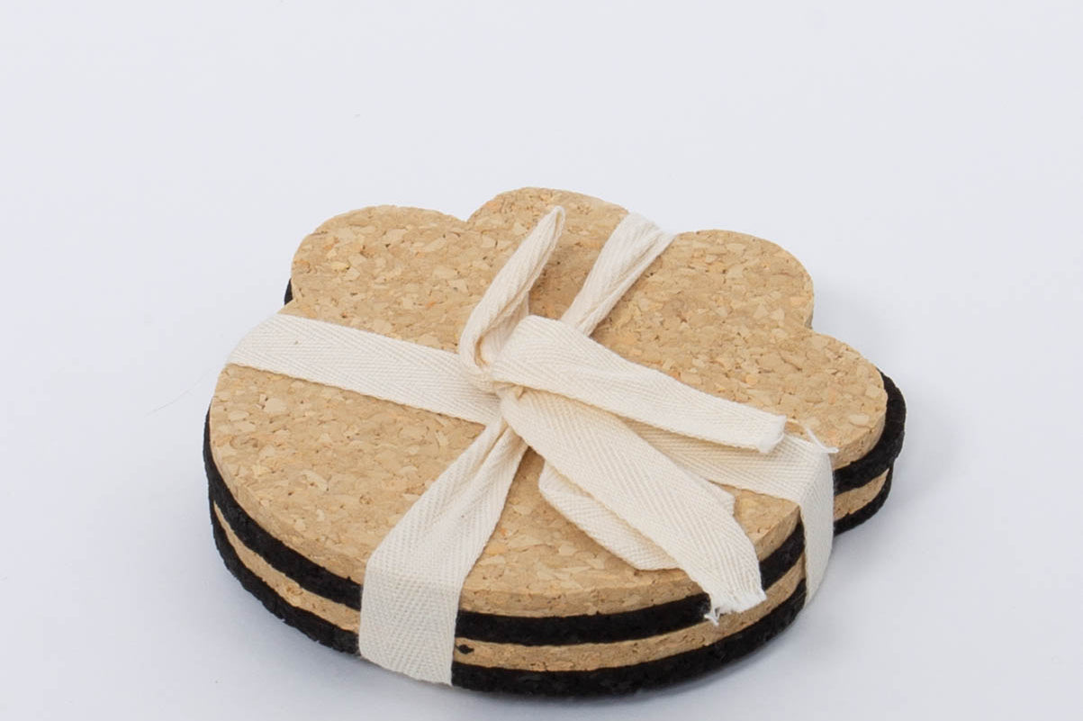 100% Recycled Dog Paw Rubber Coaster Set in tan and black by Ore Originals tied together with cream ribbon.