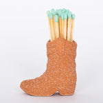 Terracotta Cowboy Boot Match Holder This vintage-inspired ceramic cowboy boot match holder includes 25 safety matches that are easily lit with a strike on the bottom of the boot! After the safety matches run out, this holder is compatible with any match and can provide light by striking on the rough ceramic surface.