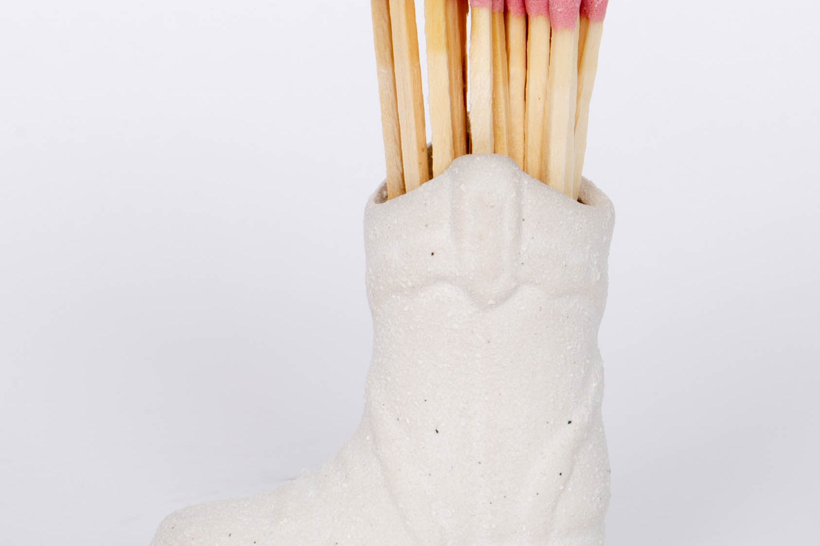White Cowboy Boot Match Holder This vintage-inspired ceramic cowboy boot match holder includes 25 safety matches that are easily lit with a strike on the bottom of the boot! After the safety matches run out, this holder is compatible with any match and can provide light by striking on the rough ceramic surface. 
