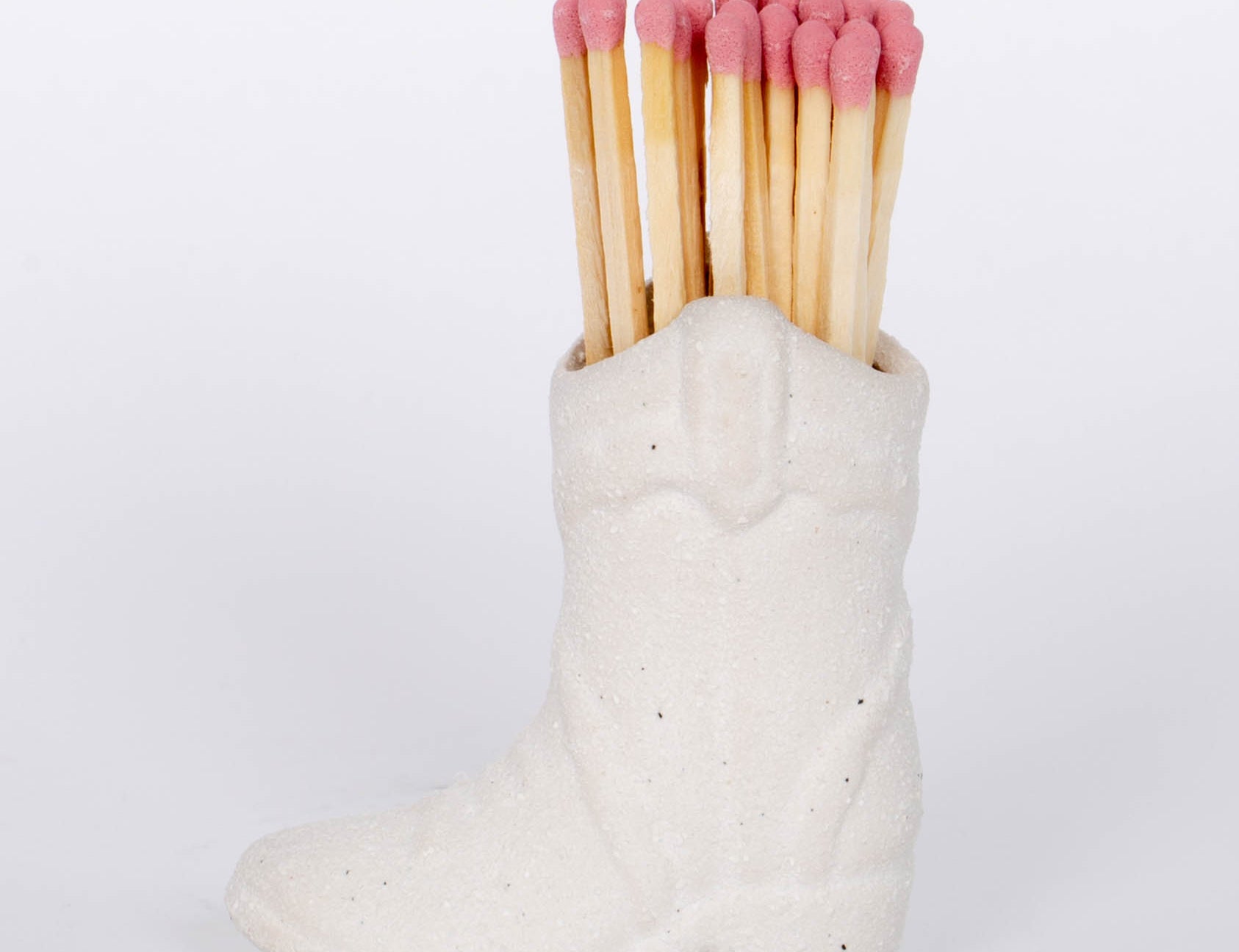 White Cowboy Boot Match Holder This vintage-inspired ceramic cowboy boot match holder includes 25 safety matches that are easily lit with a strike on the bottom of the boot! After the safety matches run out, this holder is compatible with any match and can provide light by striking on the rough ceramic surface. 