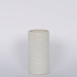 Modern and striated tall ceramic Everest Pot in a matte white glaze.White background.