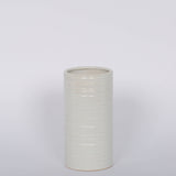 Modern and striated tall ceramic Everest Pot in a matte white glaze.White background.