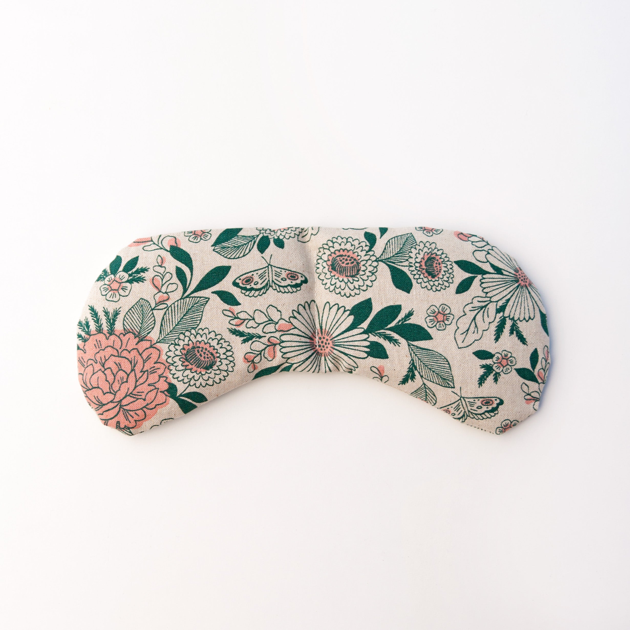 Migraine Mask by Slow North. Strap free cotton weighted eye pillow to be used hot or cold to sooth headaches and tired eyes. Tan and pink and green floral pattern. White background.