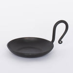 Handmade Forged Cast Iron Serving Dish with black matte finish and thin curving handle.  White background.