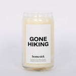 Gone Hiking Candle by Homesick. Glass jar with white candle and bold "GONE HIKING" label. White background.