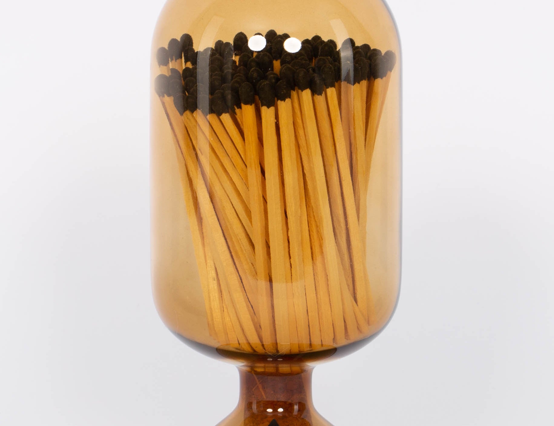 Amber Match Cloche by Skeem in jewel-toned vintage glass domes fitted with cork, holding 120 matches. White background.