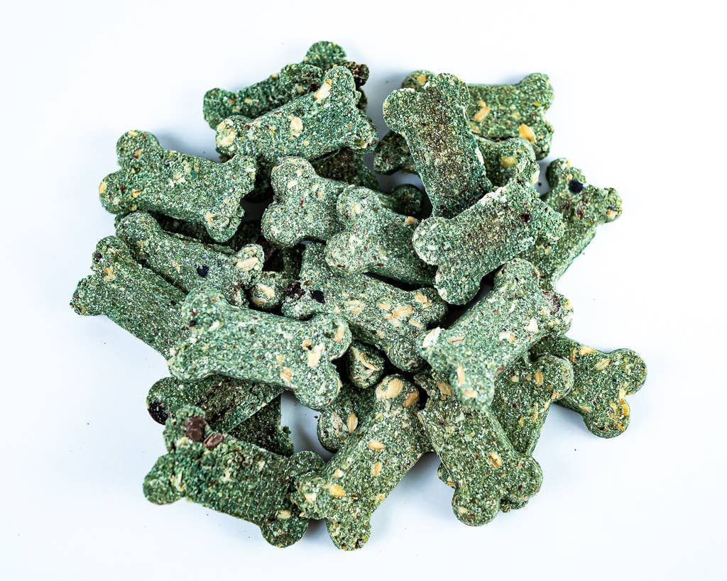 Green dog treats shaped like bones on a white background