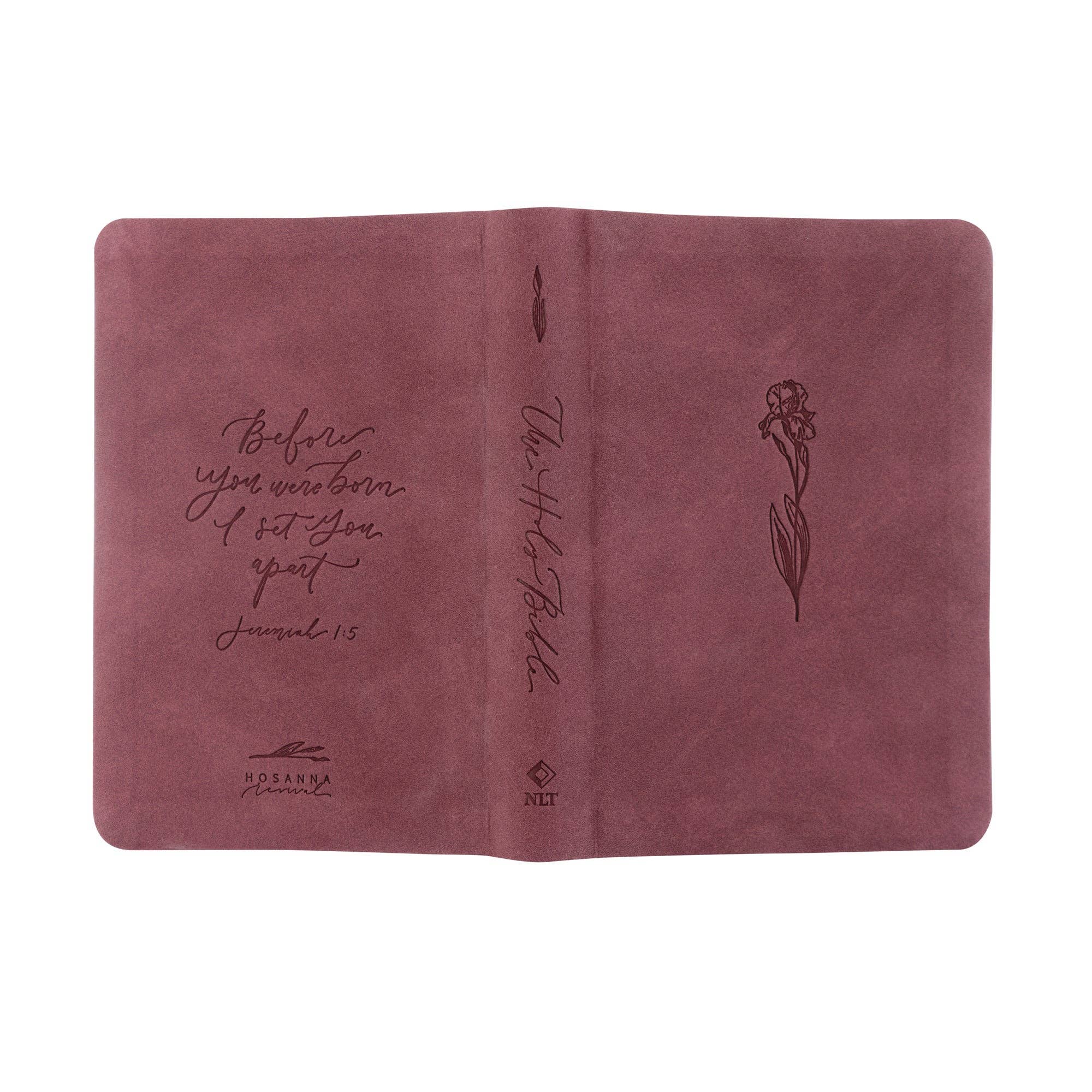 Pink leather-bound book with embossed text and a flower design on a white background