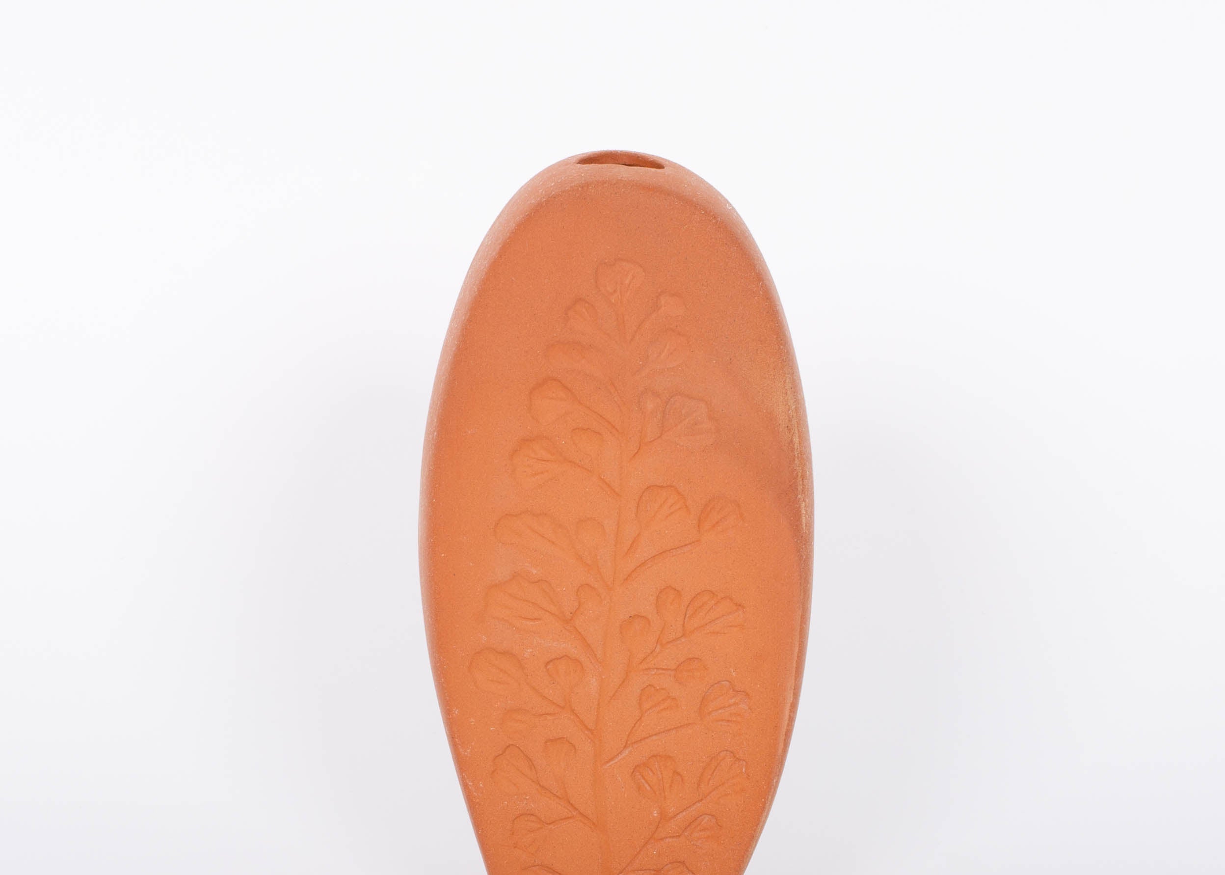 Tall oval Poppy Budvase in terracotta geometric silhouette with imprint of live plant. White background.