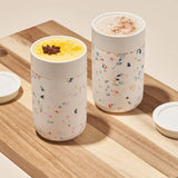 Cream Terrazzo Ceramic Porter Mug. Silicone sleeve is grippable, soft on the hands, and prevents scratches on surface. Splash-resistant lid. Microwave & dishwasher safe.