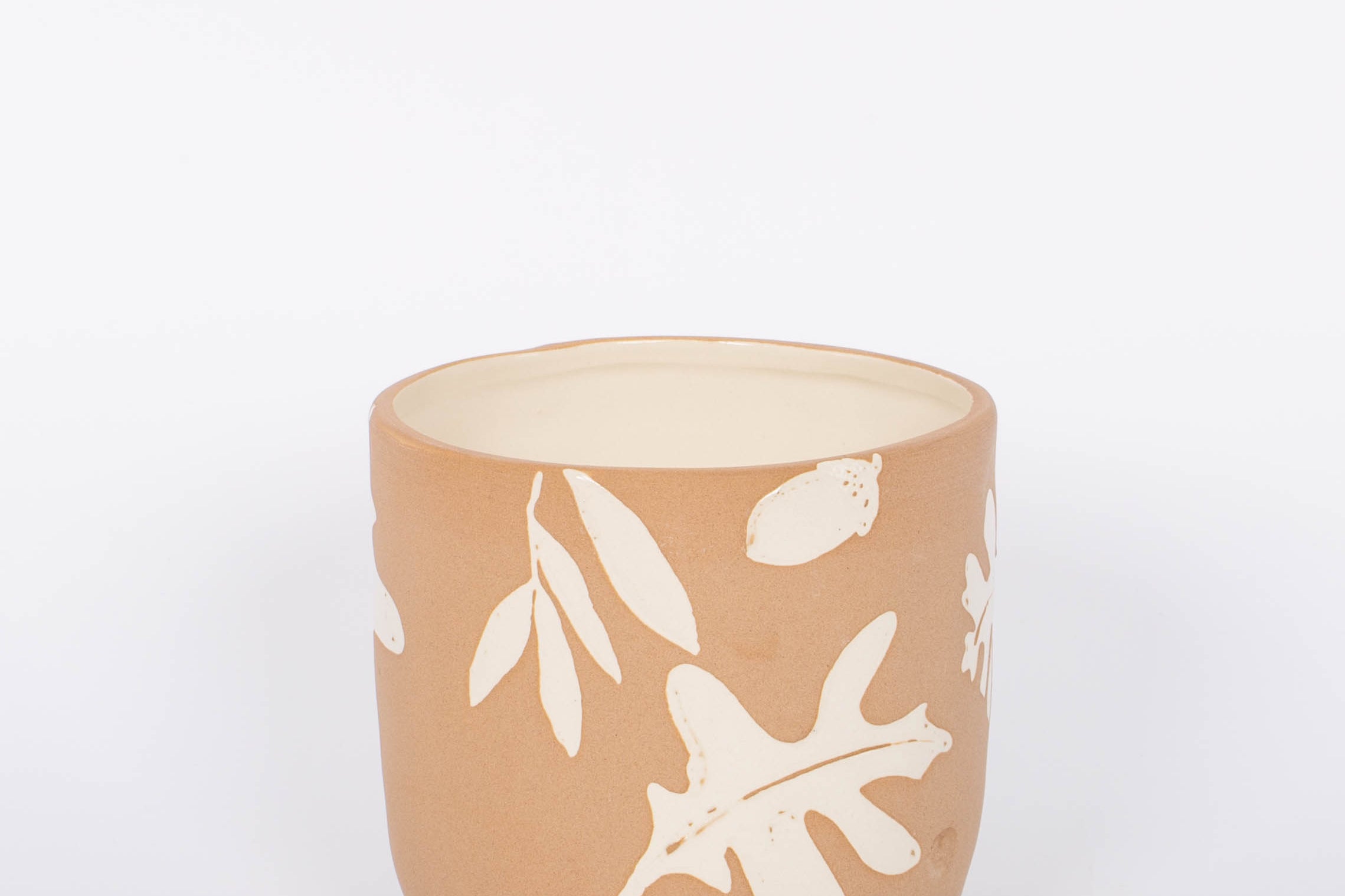 Rustling Pot with oak leaves and acorns pattern in white glazed ceramic and natural bisque. White background.