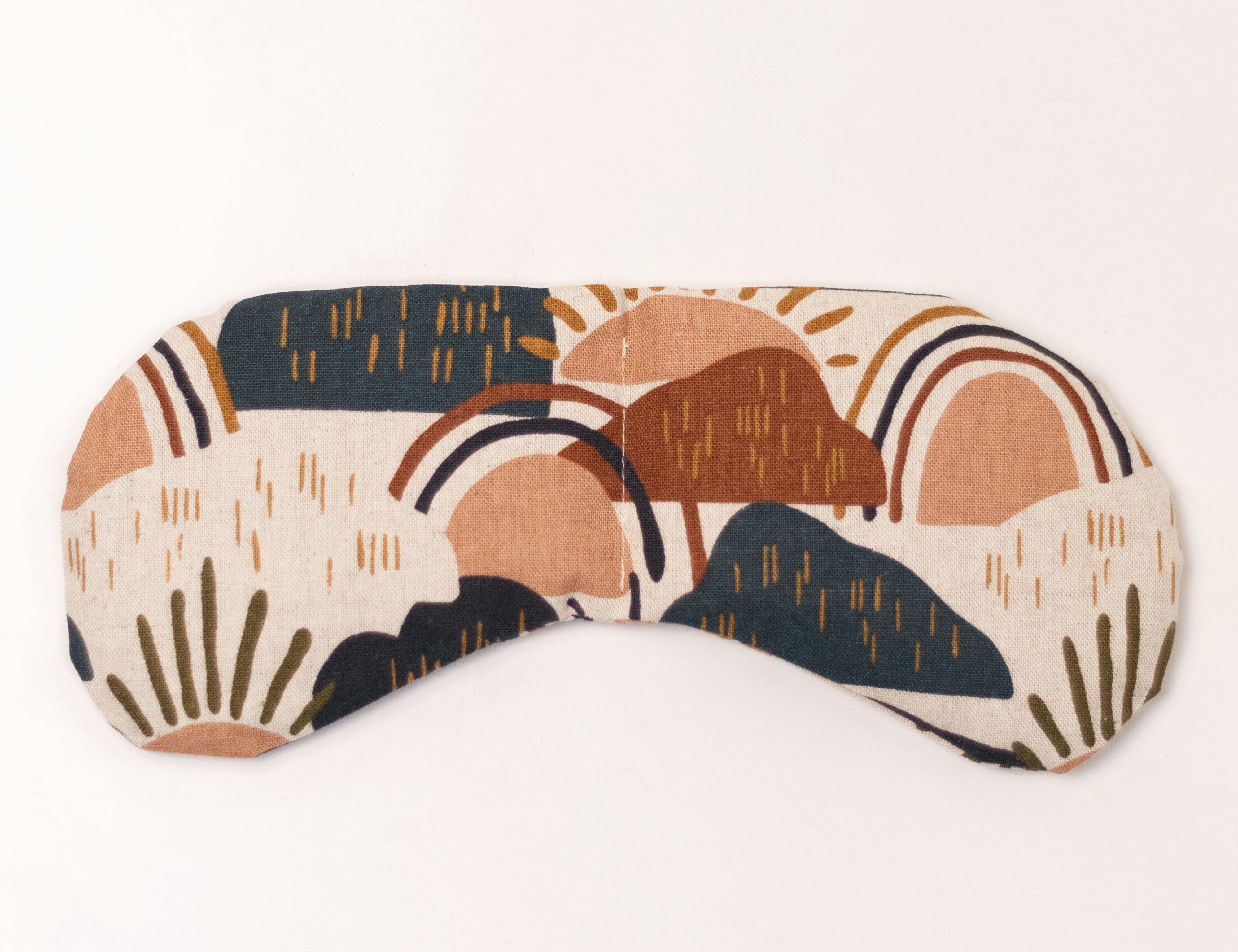 Migraine Mask by Slow North. Strap free cotton weighted eye pillow to be used hot or cold to sooth headaches and tired eyes. Tan, maroon, and navy rainstorm design. White background.