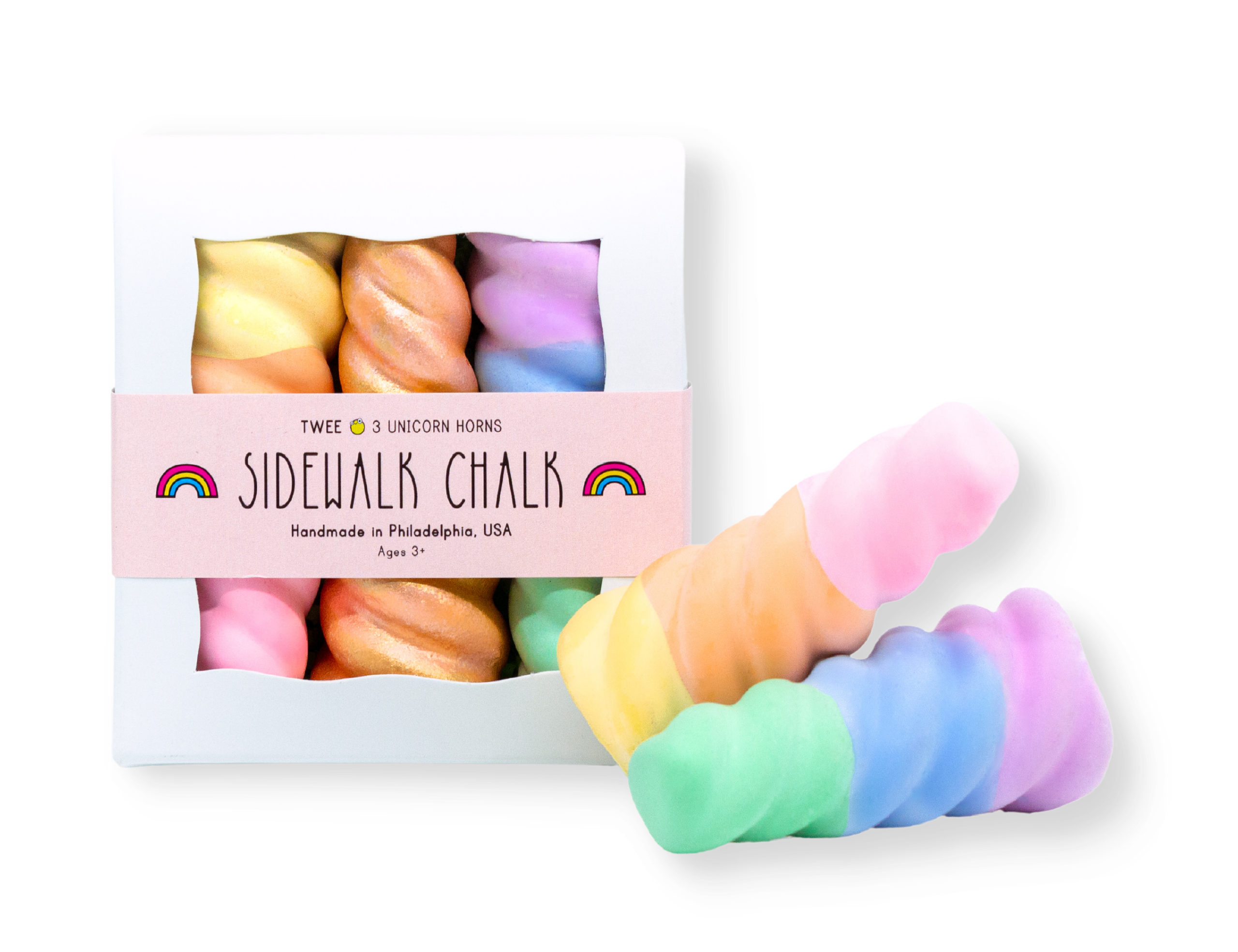 Box of TWEE Unicorn Narwhal Chalk. Three chalk pieces in gold, purple and green, and pink and yellow. Two colorful pieces outside of box.  White background. 