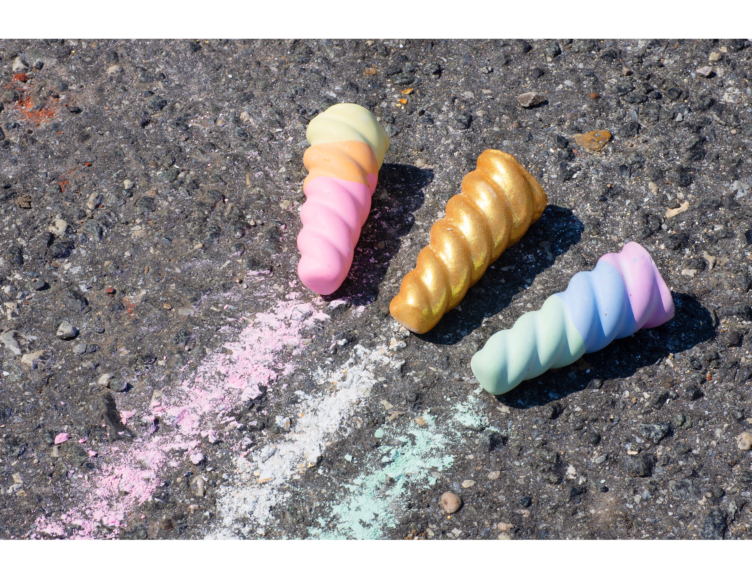 TWEE Unicorn Narwhal Chalk being used on driveway. One cool horn, one warm horn & one gold and glitter-coated white chalk horn.