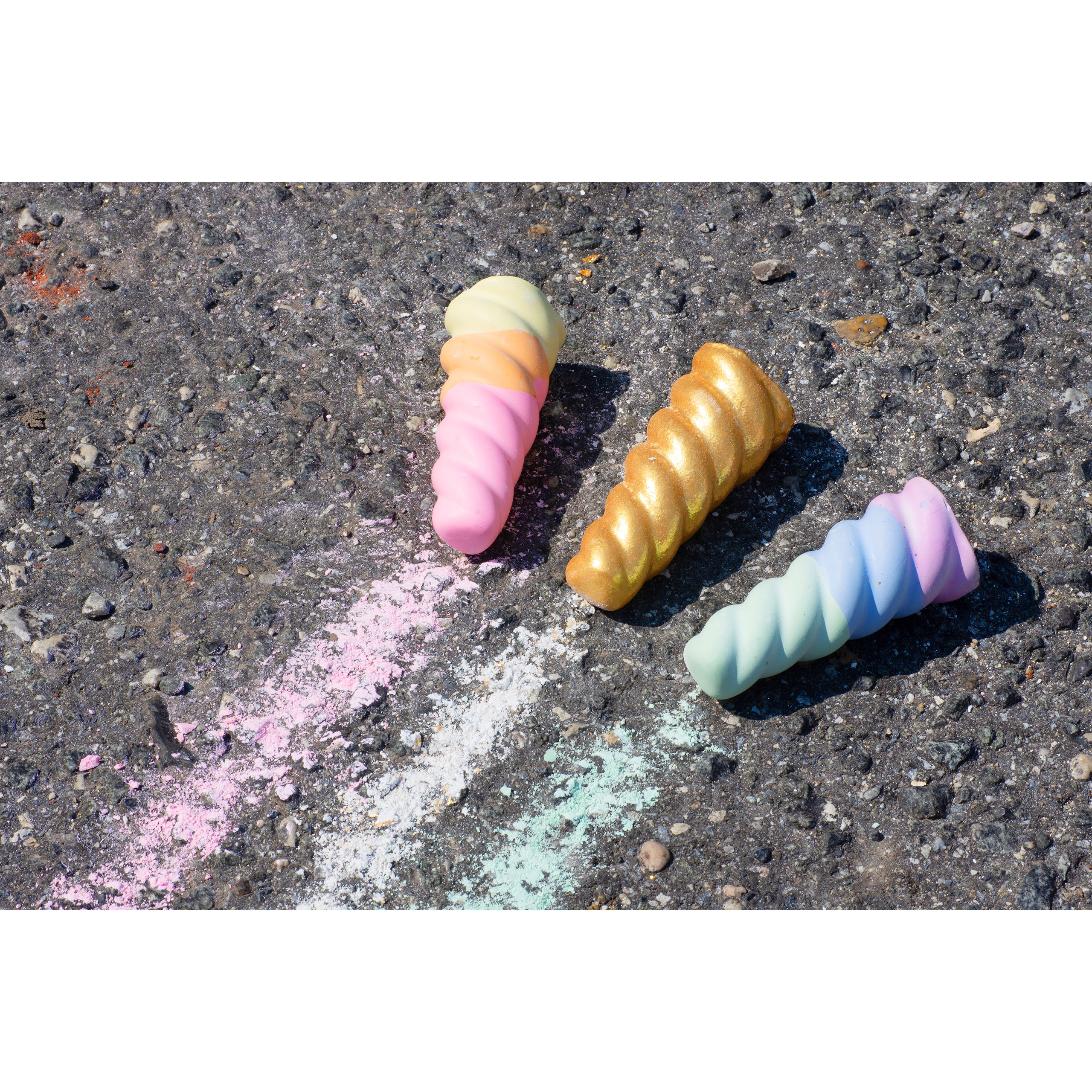 TWEE Unicorn Narwhal Chalk being used on driveway. One cool horn, one warm horn & one gold and glitter-coated white chalk horn.