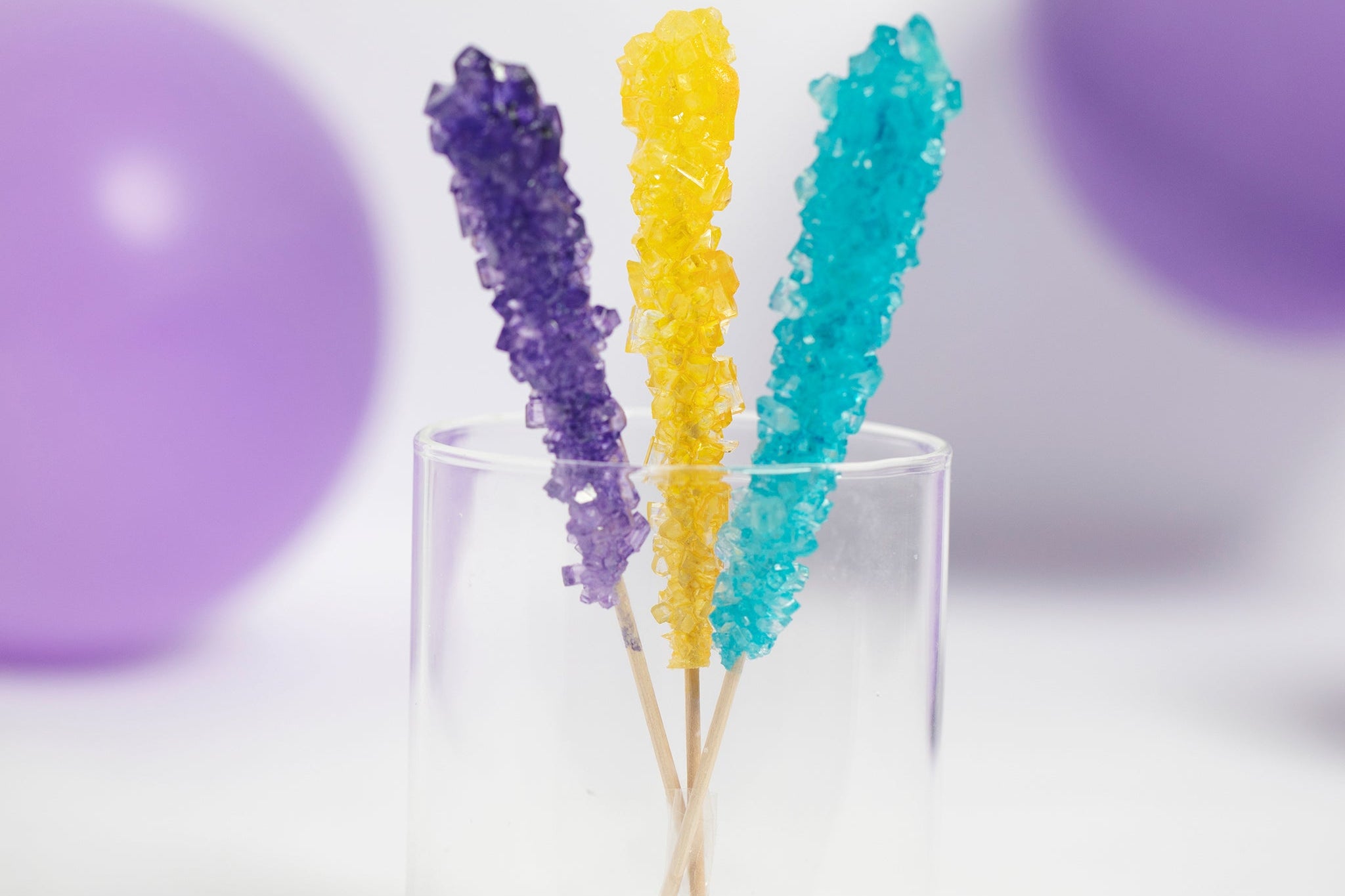 Rockin' Rainbow Rock Candy Pack by Lolli & Pops in purple, yellow, and blue with purple balloons in background. 