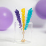 Rockin' Rainbow Rock Candy Pack by Lolli & Pops in purple, yellow, and blue with purple balloons in background. 