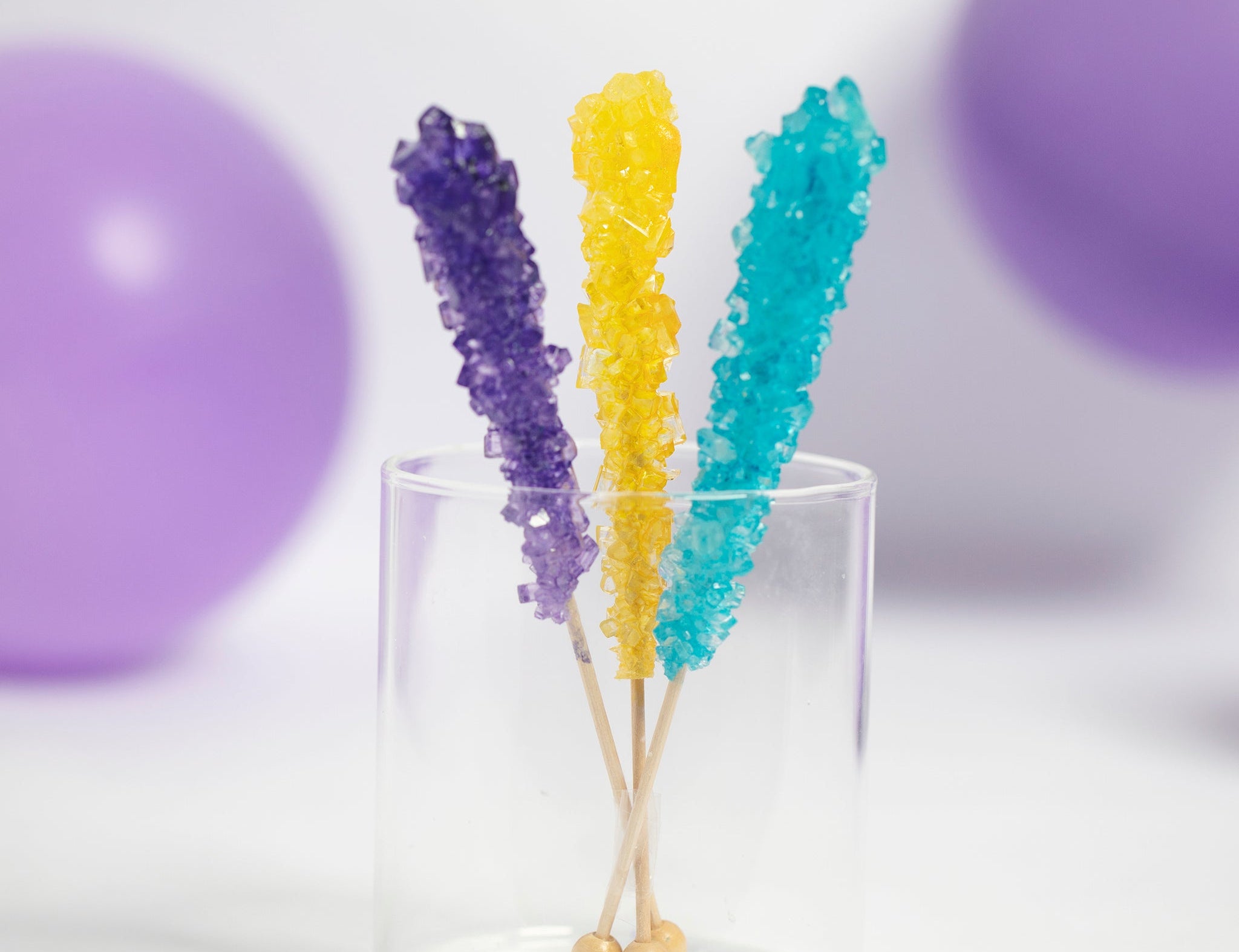 Rockin' Rainbow Rock Candy Pack by Lolli & Pops in purple, yellow, and blue with purple balloons in background. 