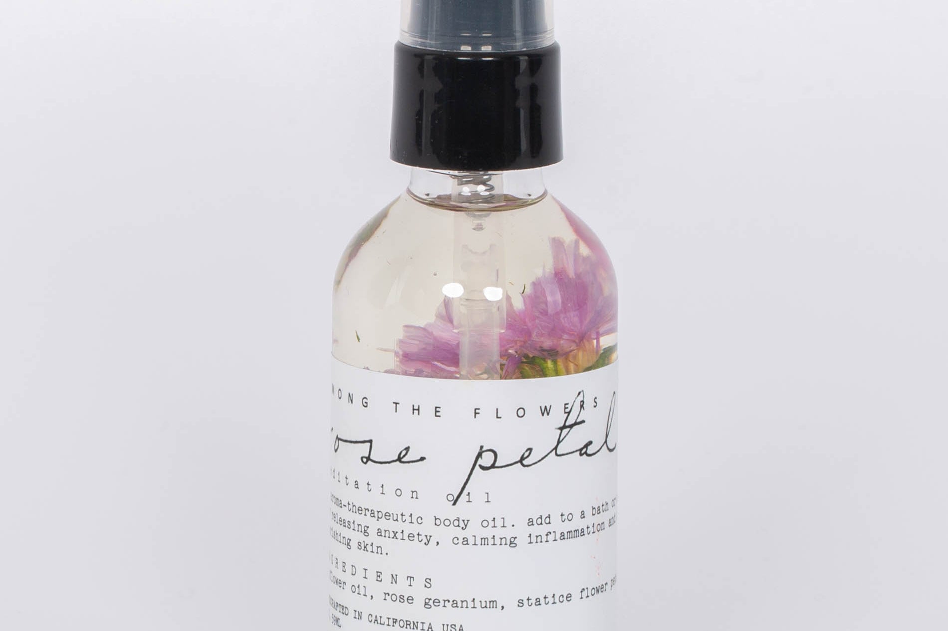 Rose Petal Body Oil by Among the Flowers in clear spray bottle white label. 