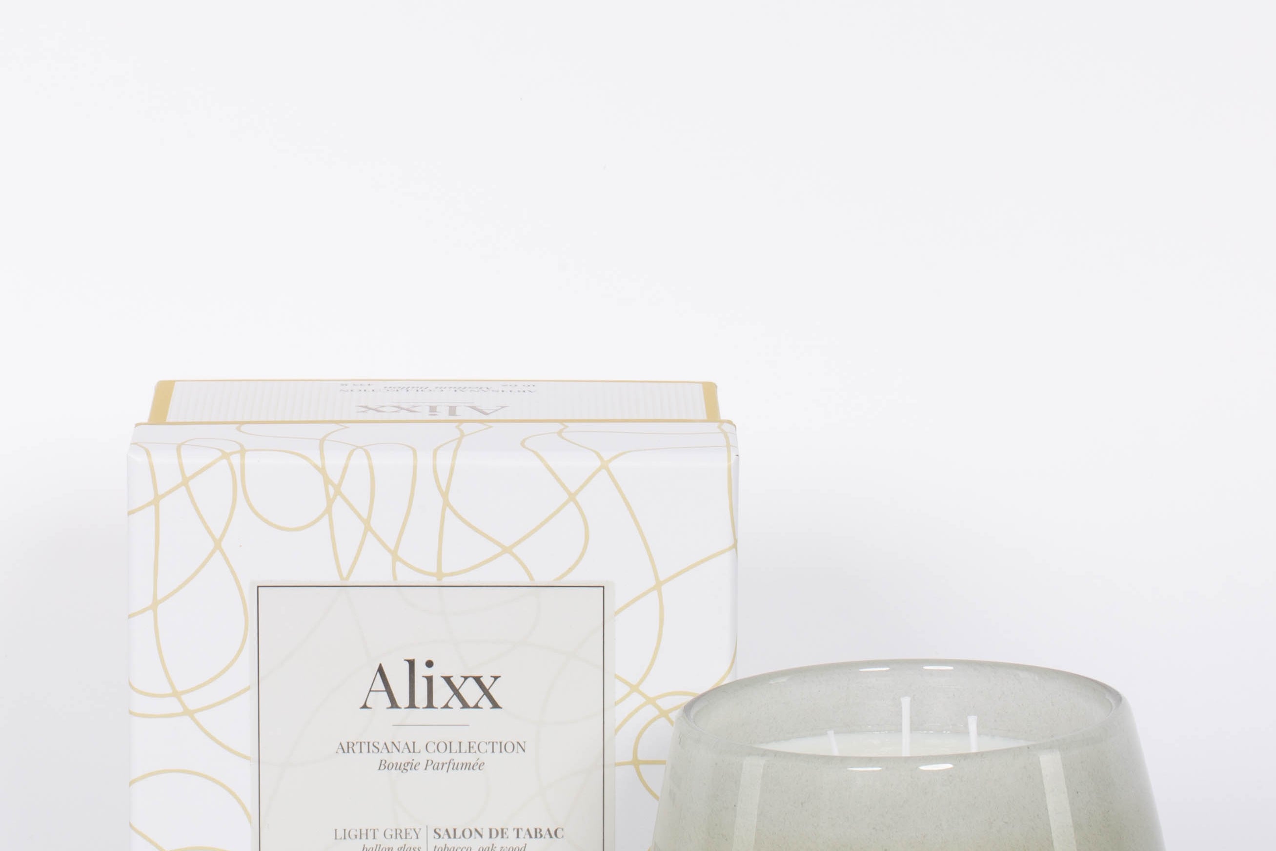 Paris inspired Salon De Tabac white two wick candle by Alixx with earthy oak wood, warm bourbon, and sweet plum nectar fragrance.  White and gold packaging box.