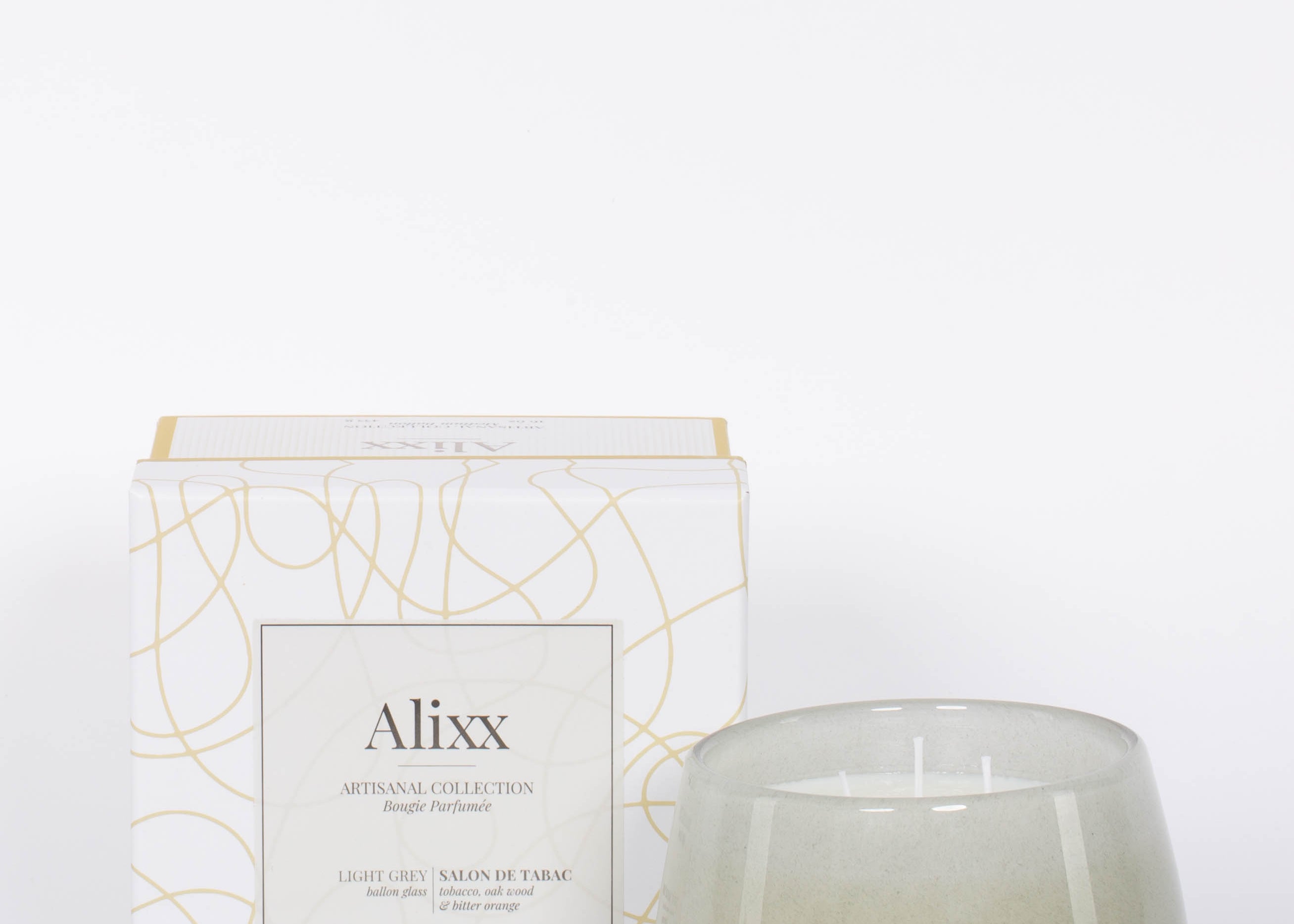 Paris inspired Salon De Tabac white two wick candle by Alixx with earthy oak wood, warm bourbon, and sweet plum nectar fragrance.  White and gold packaging box.