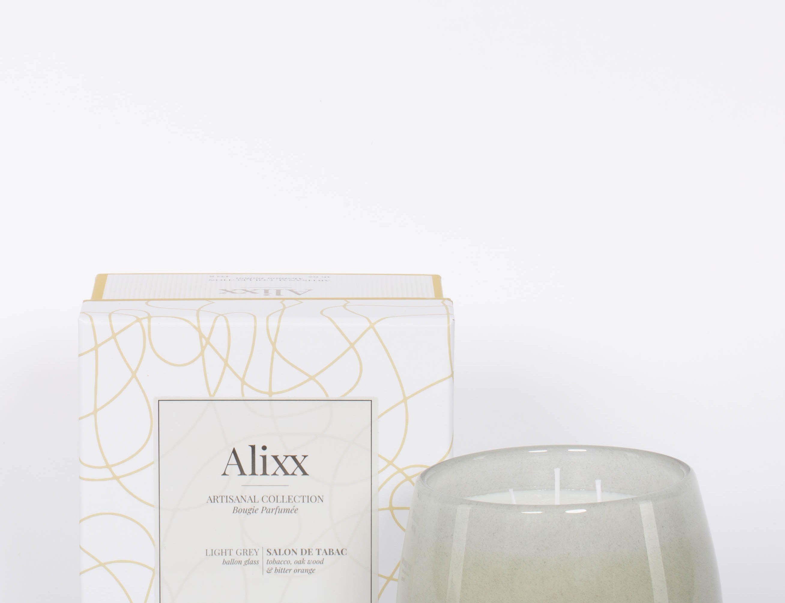 Paris inspired Salon De Tabac white two wick candle by Alixx with earthy oak wood, warm bourbon, and sweet plum nectar fragrance.  White and gold packaging box.