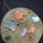 Wooden salt grinder with Himalayan salt crystals on a wooden surface