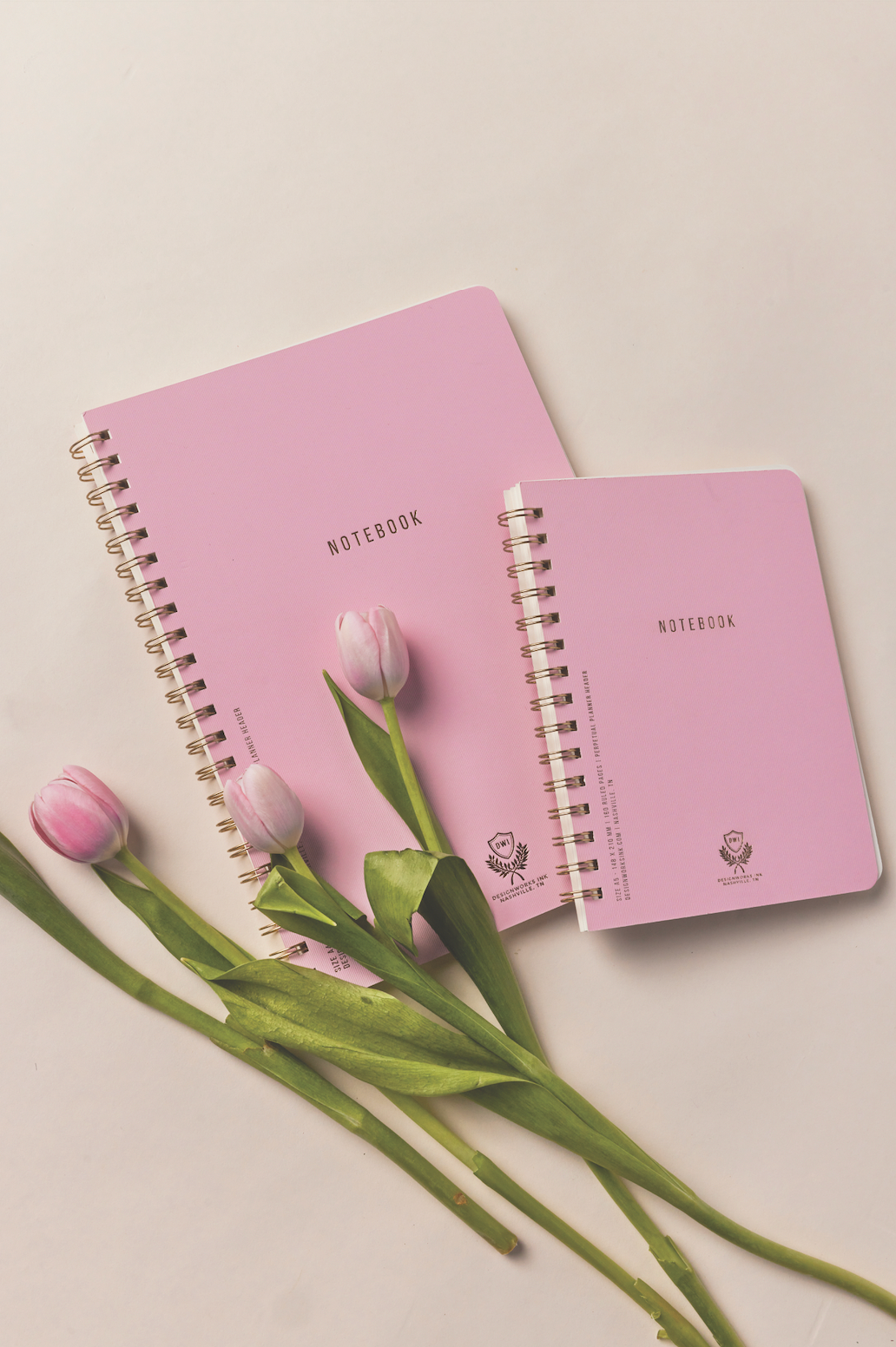 Pink and golden wire bound journals with "Notebook" on front