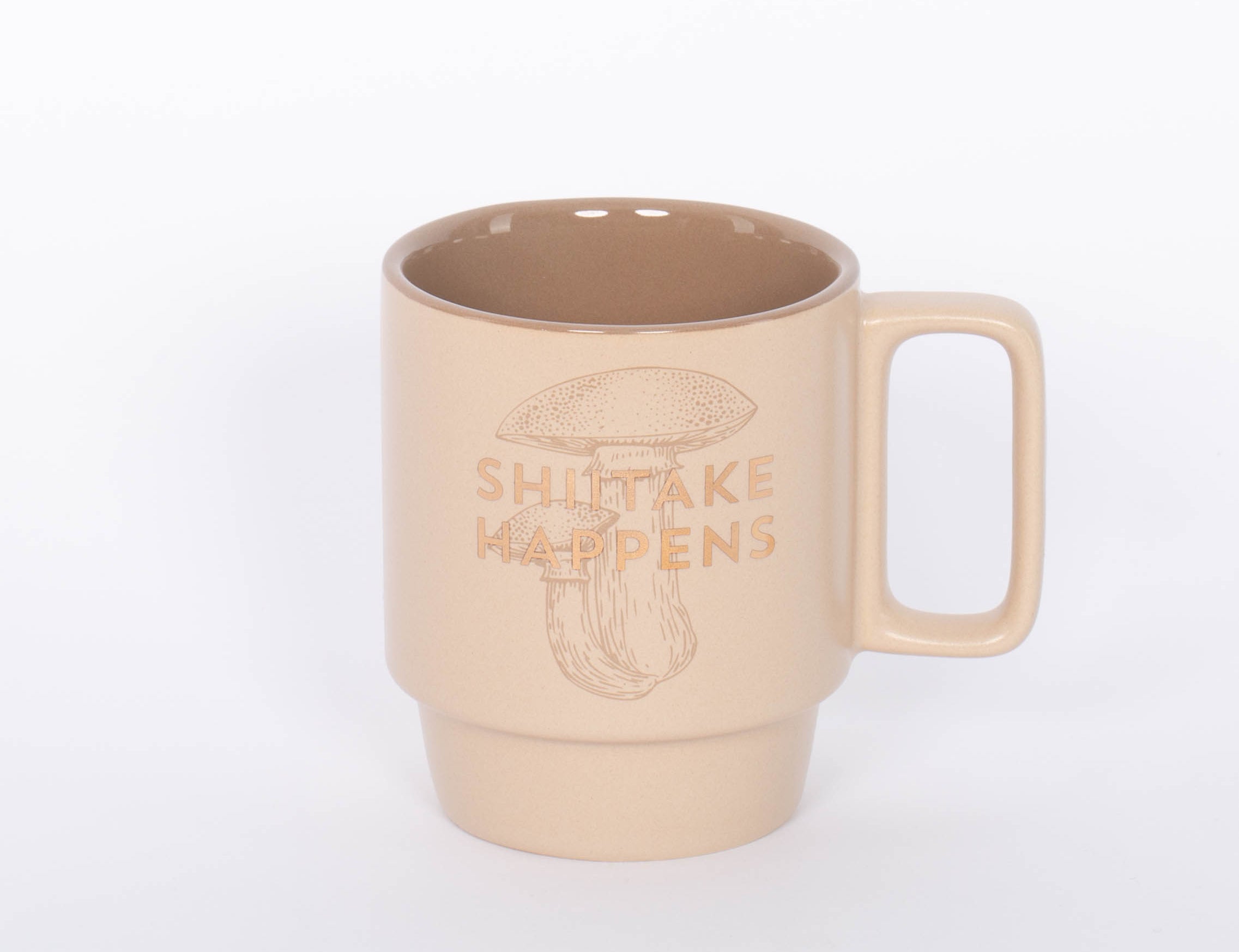 Shiitake Happens Mug. Crafted of high-quality ceramic, this stackable mug features a sassy sentiment in metallic gold lettering. This 12 oz. mushroom mug is the perfect companion to your morning routine whether it's for a cup of coffee, hot cocoa, or tea. It also makes a great gift for the mushroom lover in your life!